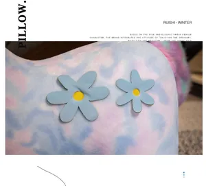 Detailed close-up of pastel tie-dye plush fur with two light blue flower applique accents