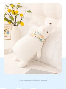 Soft white polar bear plush toy with floral scarf shown in a cozy home bedroom setting