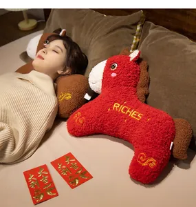 Vista dettagliata di un peluche di cavallo rosso con ricamo RICHES in camera da letto