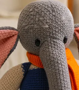 Gros plan d'un éléphant en peluche tricoté doux avec des textures fines et des yeux mignons.