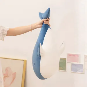 Cuddly blue and white whale plush toy pillow held by hand in a soft home environment