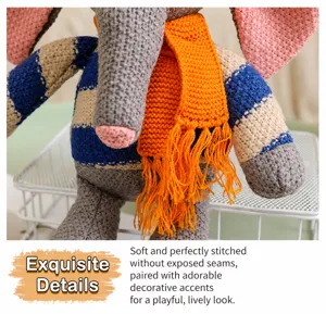 Gros plan détaillé d'un éléphant en peluche tricoté avec texture douce et écharpe orange