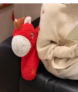Dettaglio di un simpatico cavallo di peluche rosso tenuto da una persona sul divano