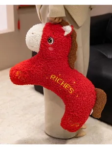 Dettaglio di un simpatico peluche a forma di cavallo rosso con ricamo RICHES e morbido
