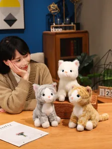 Primo piano di tre bambole gattino di peluche realistiche nei colori bianco, grigio e zenzero