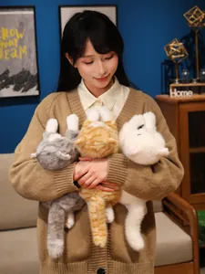 Vista dettagliata di una modella asiatica che tiene tre gatti di peluche realistici.