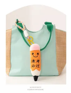 Detail of a smiling plush pencil charm with Chinese embroidery on a stylish summer bag