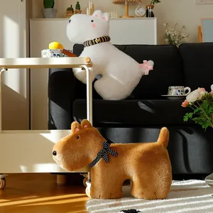 Cute plush dog toys with decorative bowties displayed on a sofa for home decor birthday gift