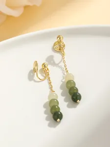 Close-up of elegant gold-toned non-pierced ear clips with gradient green beads