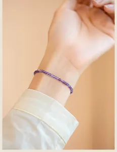 Detail view of a delicate 2mm lavender amethyst beaded bracelet on a woman's wrist