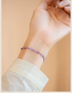 Close-up of extra fine 2mm natural lavender amethyst beaded bracelet on a woman's wrist