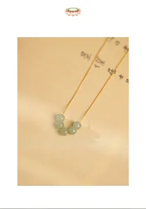 Close-up of S925 silver gold-plated necklace with five green Hetian jade beads