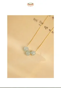 Detailed macro shot of vintage Chinese style necklace with three Hetian jade beads on box chain