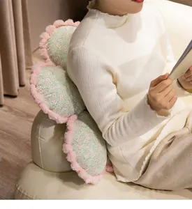 Gros plan d'un coussin en peluche floral utilisé comme dossier confortable sur un canapé