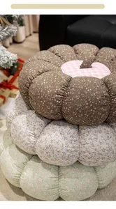 Primer plano de tres cojines de suelo con forma de calabaza floral en un salón acogedor