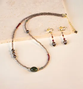 Detalle de este conjunto de collar y pendientes de cuarzo ahumado hechos a mano oro