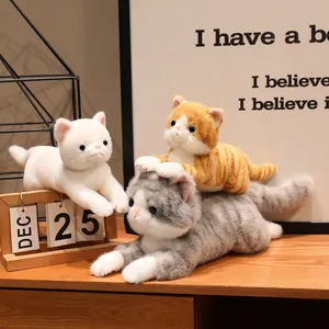 Tre realistici gatti di peluche morbidi in bianco, arancione e grigio tigrato