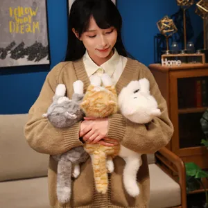 Ragazza tiene in braccio tre teneri peluche di gatto realistici