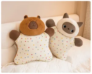 Un par de lindos cojines de peluche de capibara y gato colocados en una cama blanca