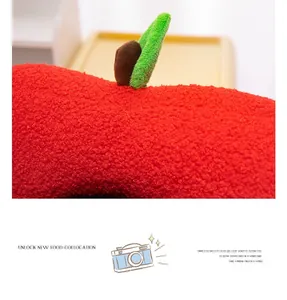 Macro view of apple plush pillow showing soft red curly fleece texture and green leaf