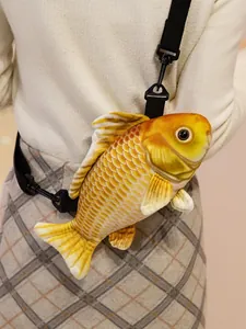 Detailweergave van een realistische goudvis pluche crossbody tas gedragen door model.