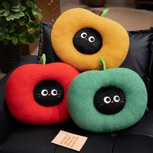 Three colorful apple-shaped cat plush cushions displayed on a black leather chair