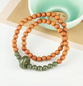 Detail of sandalwood bead bracelet with green jade runner and double loop design