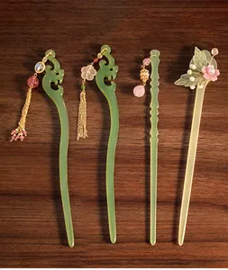 Dettaglio di quattro eleganti forcine cinesi in acrilico con nappe e cristalli fini
