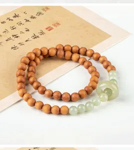 Detailed view of a double-strand sandalwood and jade bead bracelet with a central ring.