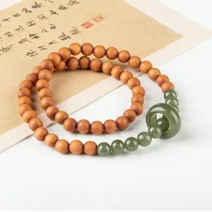 Detailed view of a double-loop sandalwood bracelet with green jade beads and a running ring