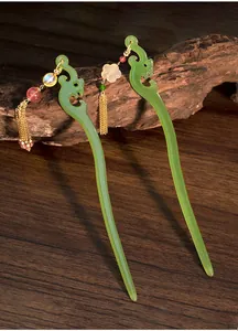 Dettaglio dei fermagli per capelli drago verde in acrilico con nappine in cristallo