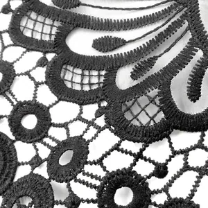 Detail macro view of black water-soluble lace collar with 3D embroidery on organza