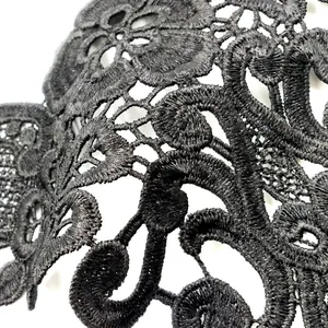 Macro view of detailed black guipure lace embroidery with intricate floral patterns