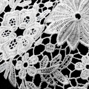 Detaillierte Makroaufnahme der eleganten weißen Guipure-Spitze mit Blumenstickerei