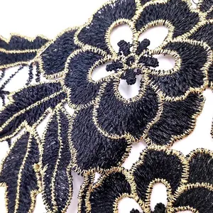 Detailed macro view of black and gold heavy embroidered water-soluble floral lace applique