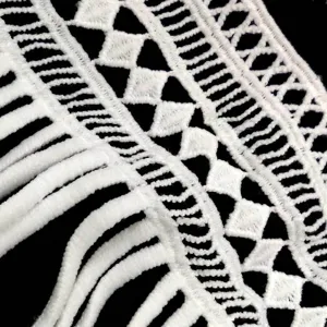 Detailed macro shot of white water-soluble milk silk lace trim with fringe embroidery
