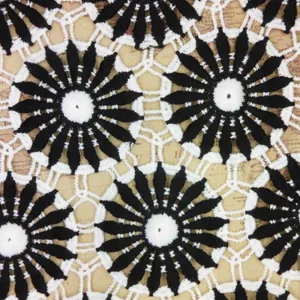 Close-up detail of black and white water-soluble lace fabric with geometric embroidery