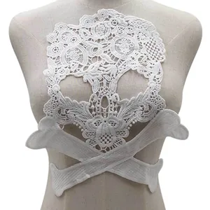 Gros plan sur un écusson en dentelle soluble blanche en forme de crâne sur un mannequin