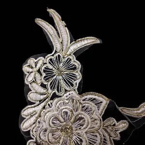 Macro view of white and gold floral embroidered lace applique for DIY sewing projects