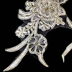 Macro view of the intricate gold and white thread patterns in floral embroidery lace