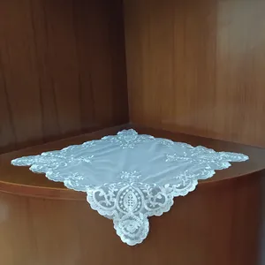 Close-up detail of white mesh lace tablecloth featuring intricate floral embroidery