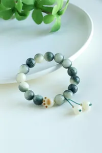 Detail of bodhi bead bracelet featuring an engraved six-character mantra and cat paw