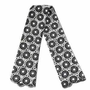Detailed macro view of black and white water soluble guipure lace fabric with geometric floral patterns