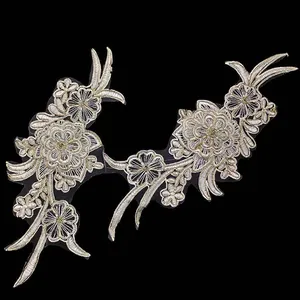 Detailed view of intricate gold and white floral bone embroidery lace applique patch
