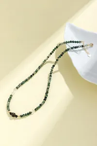 Gedetailleerde weergave van een vintage natuurlijke mosagaat kralenketting voor dames