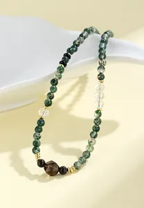 Detailopname van natuurlijke mosagaat ketting met kristallen kralen en gouden accenten.