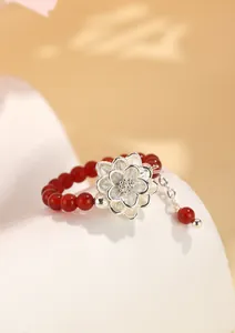 Primer plano de un anillo de cuentas de ágata roja con una delicada flor de loto de plata S925