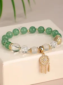 Detailansicht eines Perlenarmbands mit grünen Steinen, weißem Quarz und Sonnenanhänger.