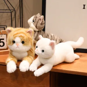 Primo piano di tre adorabili gatti di peluche simulati in arancione, grigio e bianco.