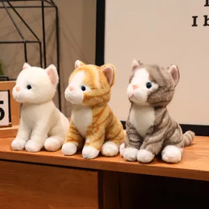Vista dettagliata di tre peluche realistici a forma di gattino in bianco, arancio e grigio